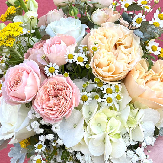 A bright flower arrangement featuring pink and yellow roses