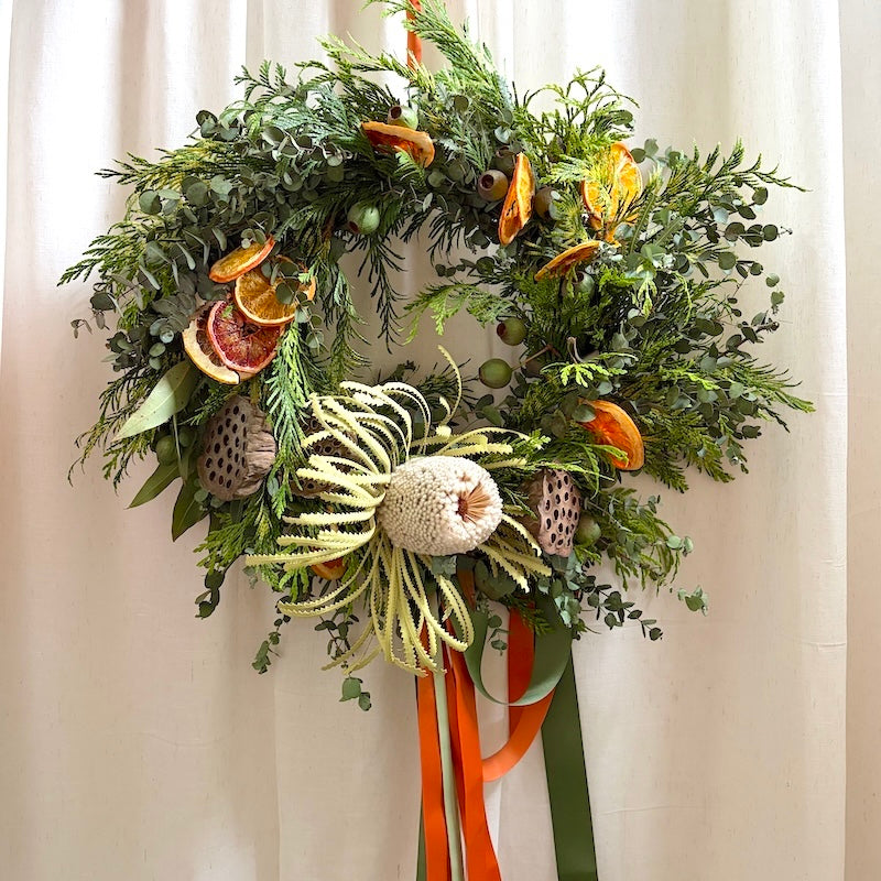 Classic style fresh Christmas wreath with pine, eucalyptus, banksia and dried orange, made at the Flowers Alley wreath workshop in Cheltenham