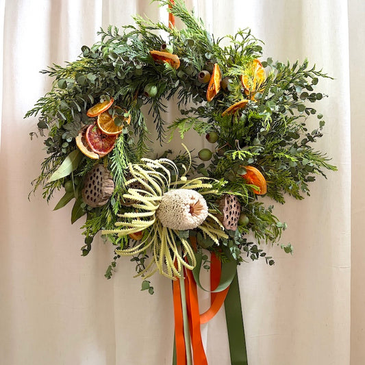 Classic style fresh Christmas wreath with pine, eucalyptus, banksia and dried orange, made at the Flowers Alley wreath workshop in Cheltenham