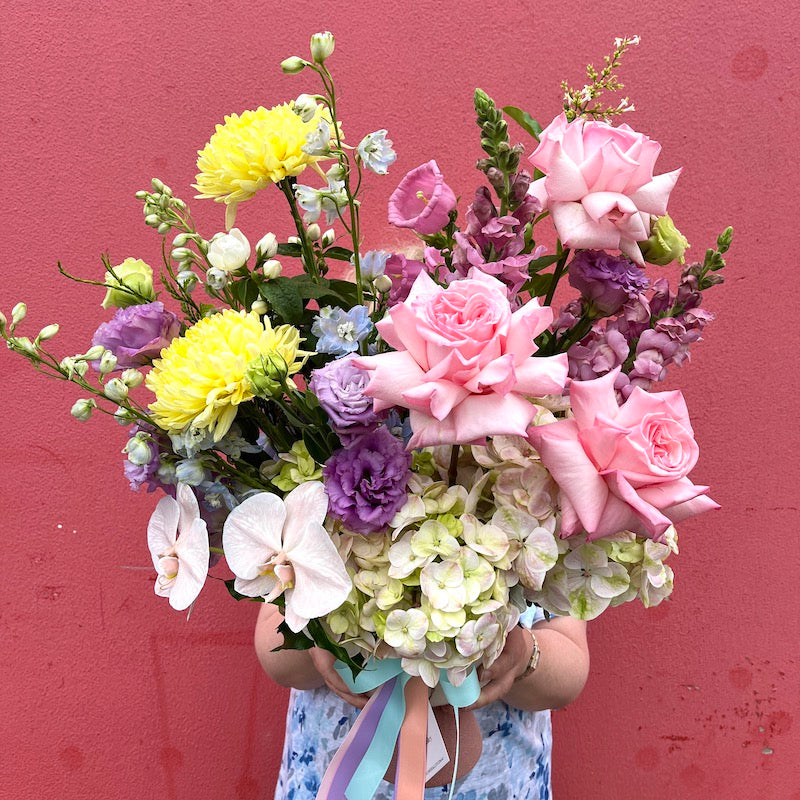 Bouquet held against the Flowers Alley pink wall