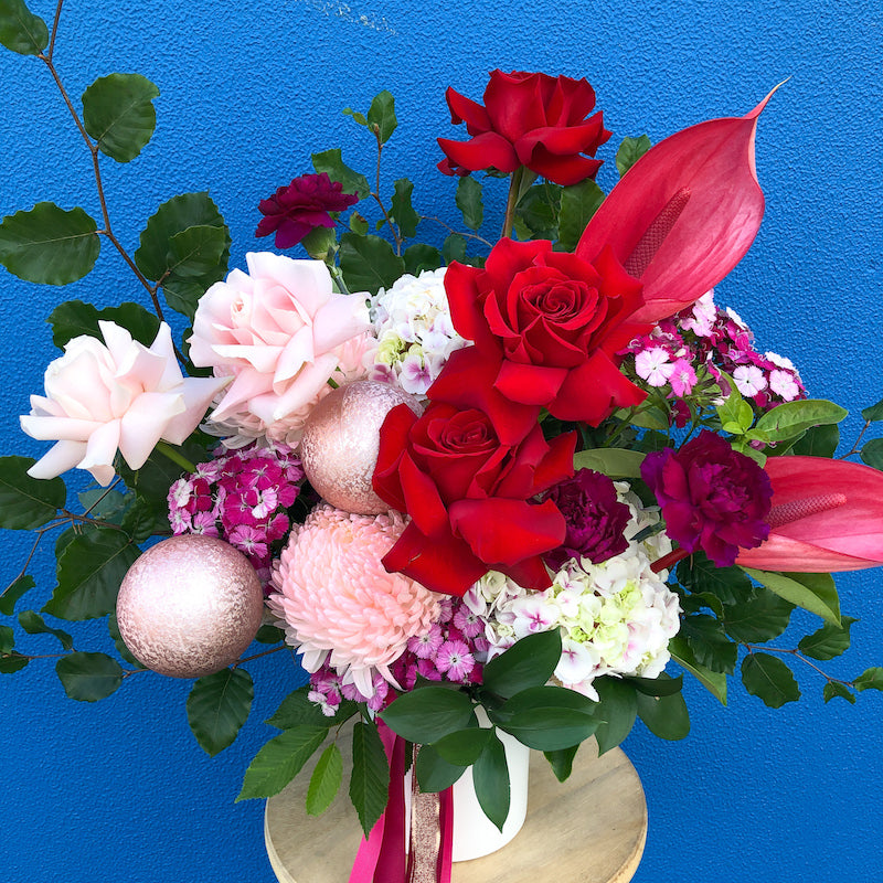 Red and pink christmas flower arrangement delivery in melbourne